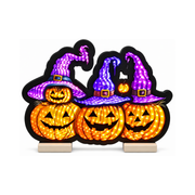 Decorazione luminosa Halloween con quattro zucche arancioni affiancate, con cappelli da strega viola e blu