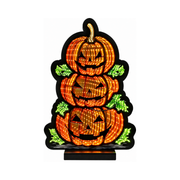 Decorazione luminosa Halloween con tre zucche arancioni sovrapposte, foglie verdi illuminate e base nera