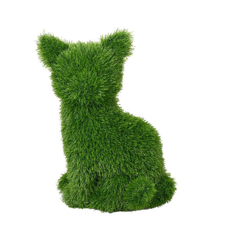 Gatto decorativo seduto in prato sintetico verde.