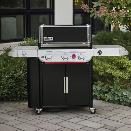 Barbecue a gas Weber Genesis EPX-335W nero e inox posizionato su una pavimentazione esterna