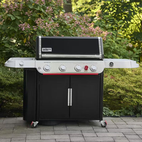 Barbecue a gas Weber Genesis EPX-435W nero e inox posizionato su una pavimentazione esterna