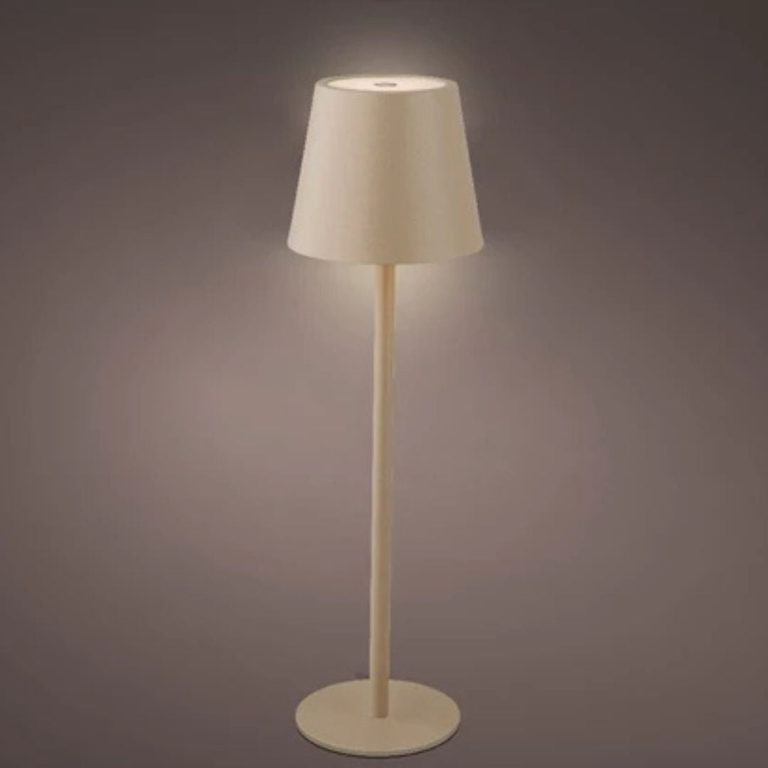 Lampada da tavolo sabbia con luce accesa, corpo in metallo, posizionata su fondo scuro