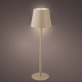 Lampada da tavolo sabbia con luce accesa, corpo in metallo, posizionata su fondo scuro