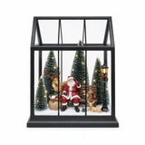 Lanterna natalizia nera con scena illuminata di Babbo Natale seduto su una panchina, renna e animali tra abeti innevati