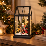 Lanterna natalizia con Babbo Natale, renna e bambino illuminata in un ambiente decorato per Natale