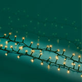 Fili di luci LED bianco caldo effetto sparkle con cavo verde su fondo turcehse.