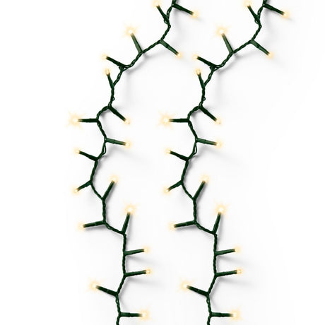 Fili di luci LED color bianco caldo con cavo verde a effetto sparkle su fondo bianco.