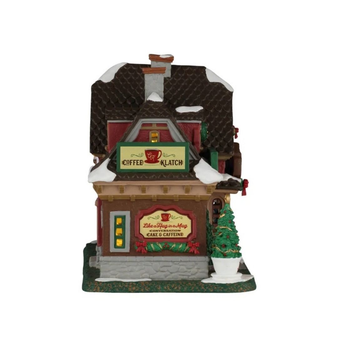 offee Klatch Lemax visto dall’altro lato, con insegne “Coffee Klatch” e “Cake & Caffeine”, tetto innevato e piccolo albero di Natale decorato.