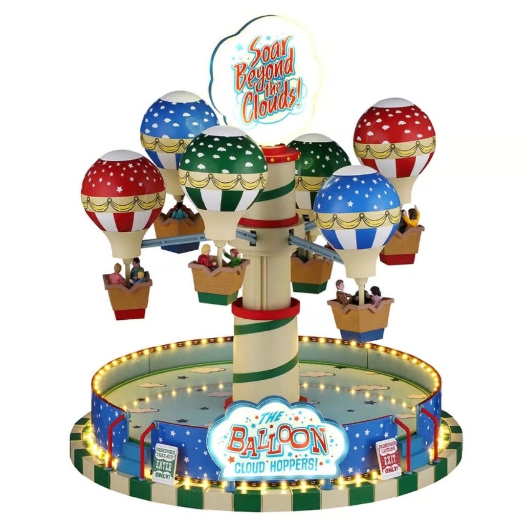 Giostra Lemax con mongolfiere colorate sospese attorno a una colonna centrale, cestelli con passeggeri e base circolare illuminata con insegne decorative.