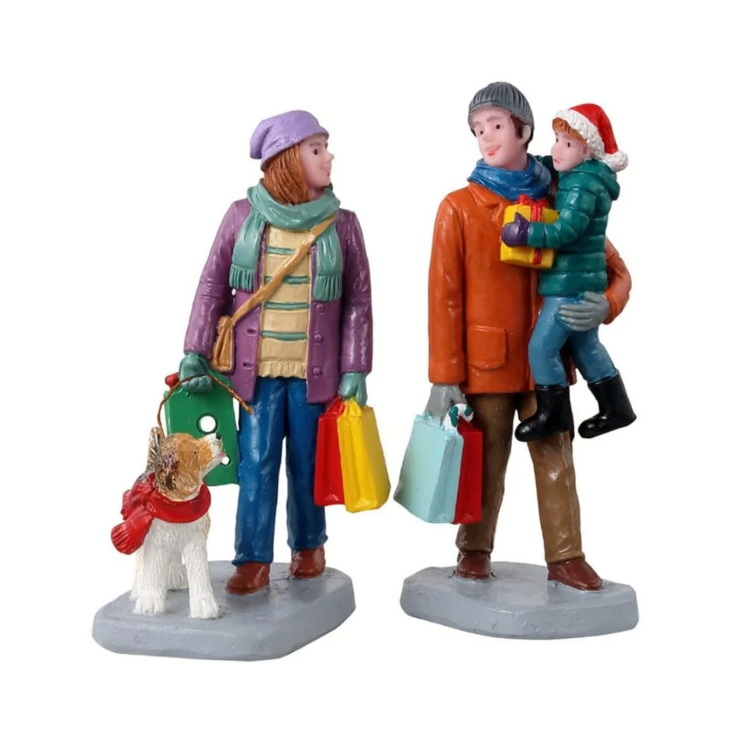 Holiday Shoppers con famiglia durante lo shopping natalizio: donna con borse e cane al guinzaglio, uomo con sacchetti e bambino in braccio con regalo.