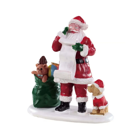 Babbo Natale che controlla la lista dei regali accanto a un sacco verde pieno di giocattoli e a un cagnolino.