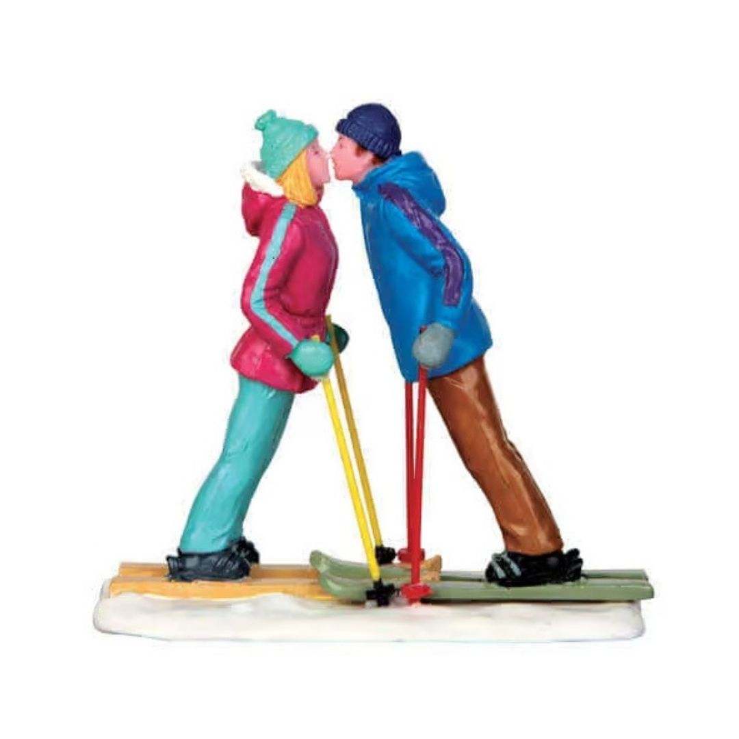Coppia di sciatori che si bacia sulla neve.