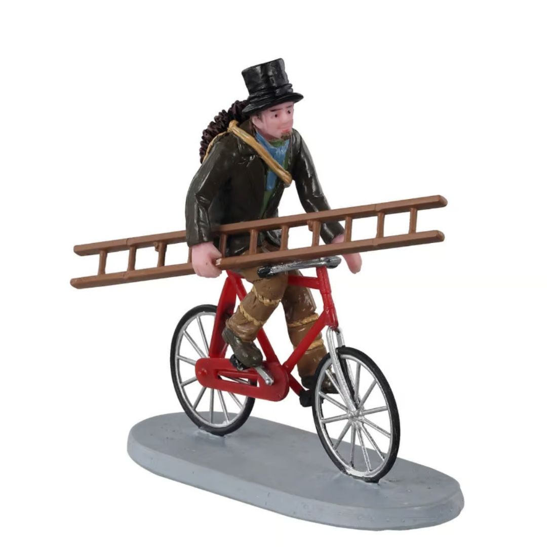 Statuetta di uno spazzacamino in bicicletta che trasporta una lunga scala e gli attrezzi da lavoro.