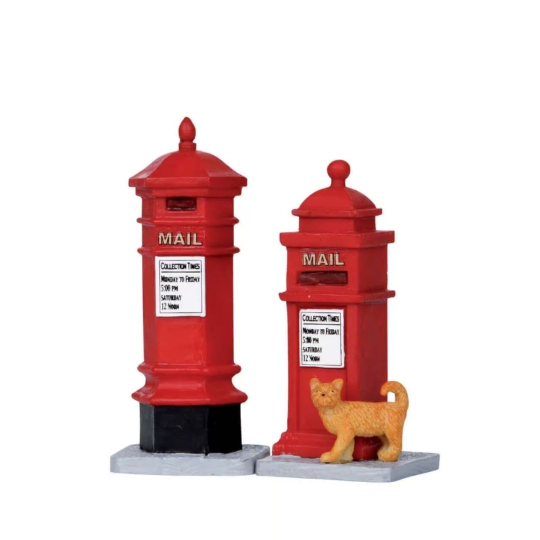 Coppia di cassette postali vittoriane rosse Lemax, una più alta e una più bassa, con un gatto arancione accanto.