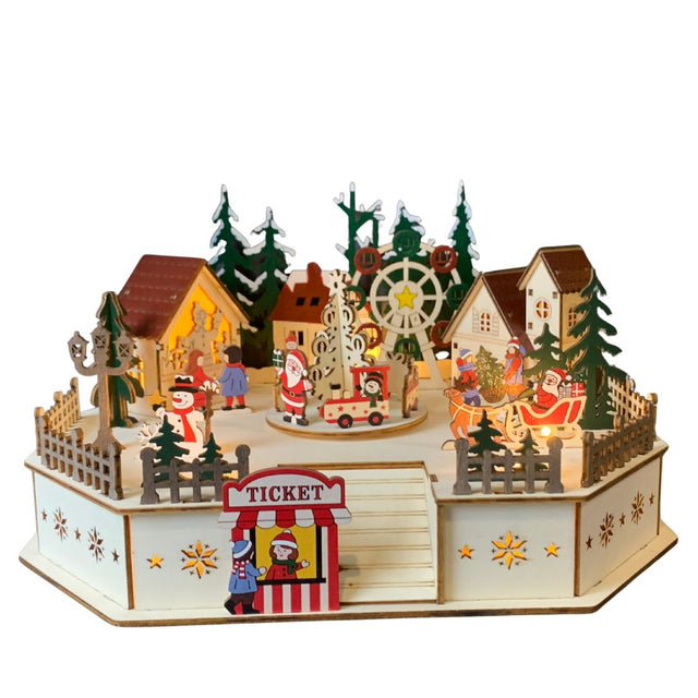 Lunapark natalizio in legno illuminato con giostra, ruota panoramica, casette, abeti, pupazzo di neve e Babbo Natale con la slitta, ambientato in un villaggio festoso.