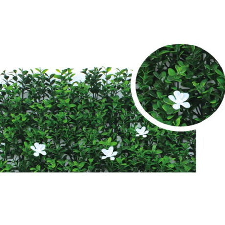 Dettaglio della mattonella di bosso sintetico con piccoli fiori bianchi.
