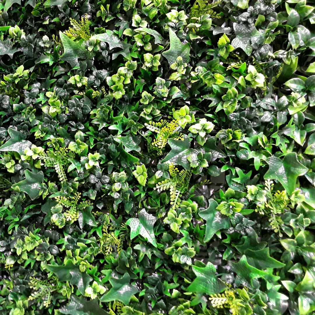 Dettaglio della mattonella di verde sintetico 50x50 cm con fogliame misto.