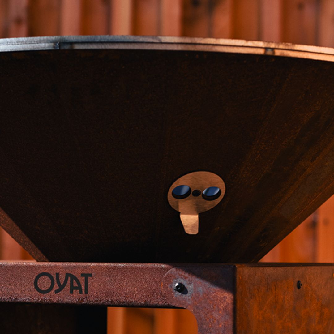 Dettaglio dei fori per rimuovere la cenere dal braciere barbecue Oyat in acciaio corten.