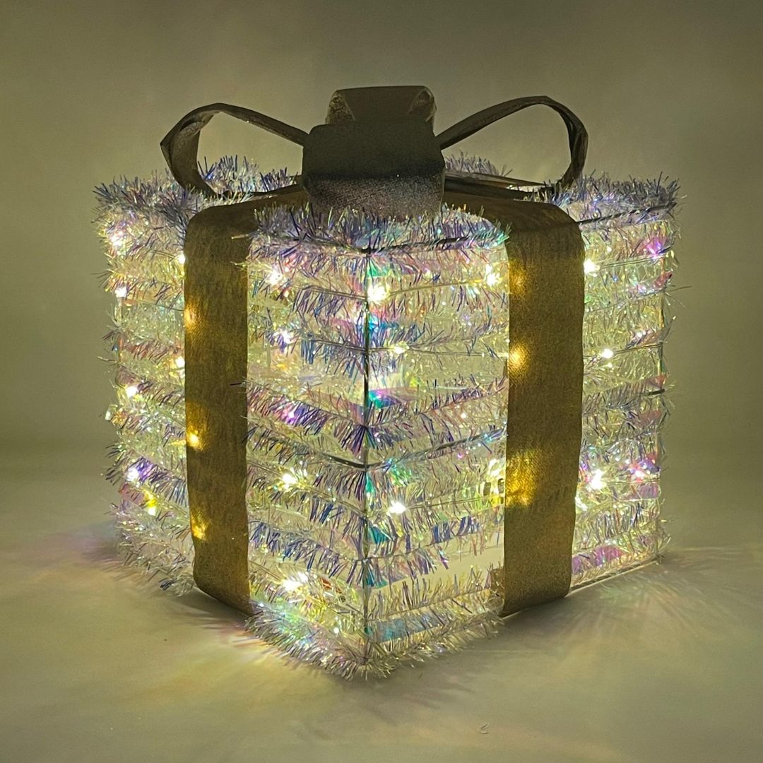 Pacco regalo 25cm luminoso quadrato con nastro dorato e luci LED diffuse attraverso la superficie brillante.