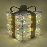 Pacco regalo 25cm luminoso quadrato con nastro dorato e luci LED diffuse attraverso la superficie brillante.