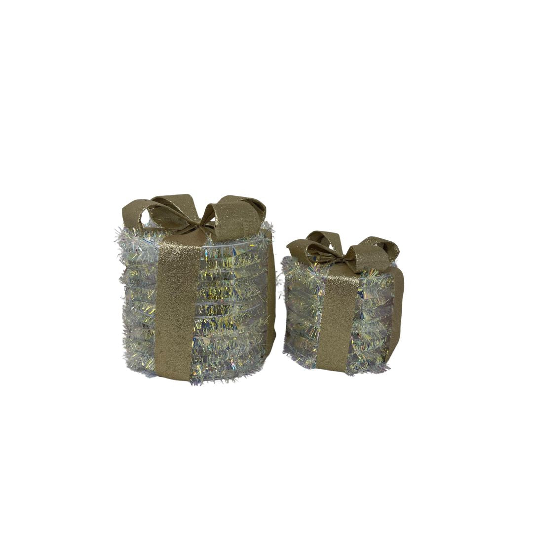 Coppia di pacchi regalo decorativi luminosi di forma rotonda con fiocco dorato e superficie riflettente iridescente.