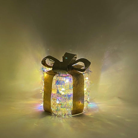 Decorazione luminosa a forma di pacco regalo rotondo con nastro dorato e luci LED.