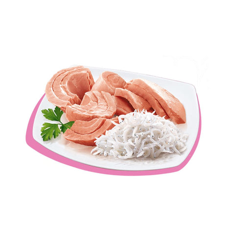 Filetti di tonno rosa con surimi su piatto bianco bordato rosa, guarnito con prezzemolo. Cibo umido per gatti.