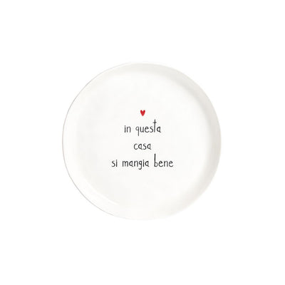 Piatto da dessert con diametro di 21 cm in gres con scritta nera "in questa casa si mangia bene" e cuoricino rosso.