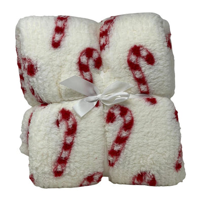 Plaid natalizio in tessuto soffice con disegno di bastoncini di zucchero candy cane su sfondo bianco, legato con nastro bianco.