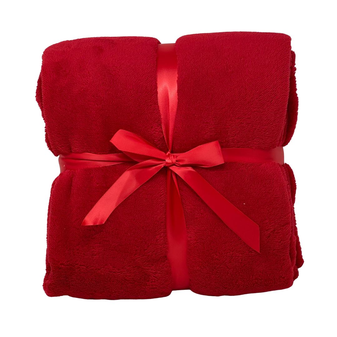 Morbido plaid rosso piegato e legato da un nastro rosso.