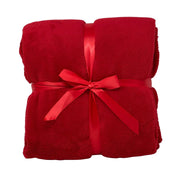 Morbido plaid rosso piegato e legato da un nastro rosso.