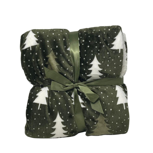 Plaid in pile verde scuro con motivo di alberelli bianchi piegato e legato con nastro verde.