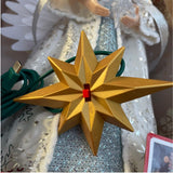 Dettaglio dell'interruttore del puntale luminoso a forma di angelo.