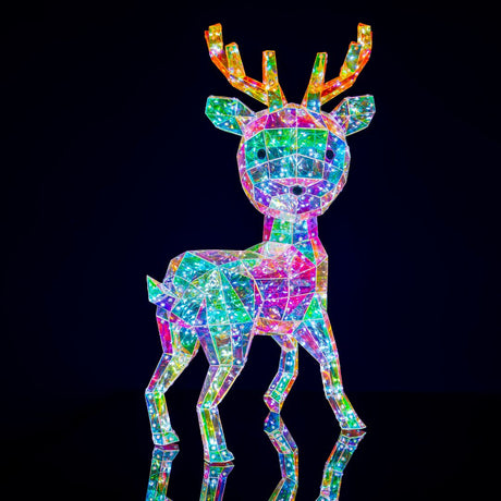 Figura decorativa natalizia a forma di renna realizzata con superfici trasparenti, illuminata internamente da micro LED che creano riflessi iridescenti su sfondo nero.