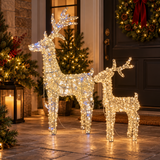 Due renne natalizie luminose Garden Team di diverse altezze, con micro LED bianco caldo, davanti a un ingresso decorato.
