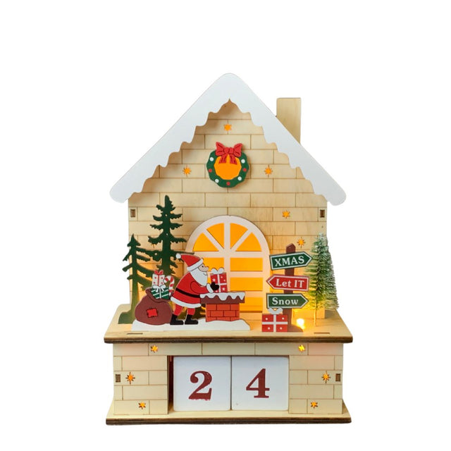 Casetta natalizia in legno illuminata con Babbo Natale che posa regali sul camino e alberelli decorativi con calendario a cubi nella parte inferiore.