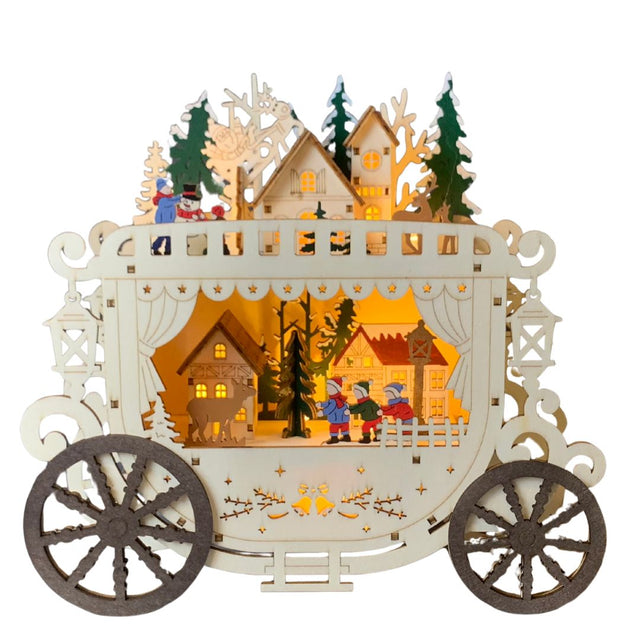 Decorazione natalizia in legno a forma di carrozza illuminata, con villaggio invernale, casette, alberi e personaggi che giocano sulla neve, arricchita da dettagli intagliati.
