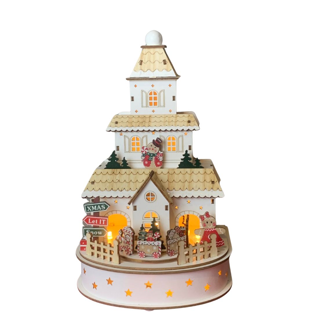 Scena natalizia in legno illuminata con casetta decorata, trenino, personaggi gingerbread e insegne festive. 