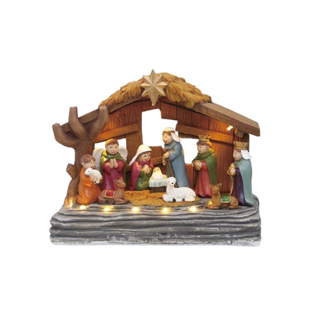 Scena della Natività con statuine colorate, capanna in legno e luci LED calde alla base su sfondo bianco.