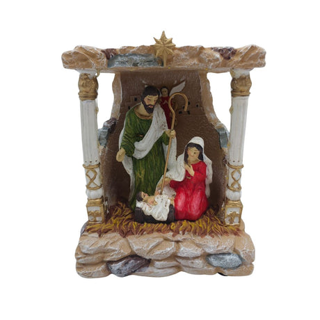 Scena della Natività in miniatura con Giuseppe, Maria e Gesù Bambino nella mangiatoia sotto una capanna illuminata con luci LED su sfondo bianco.