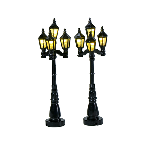 Set di 2 lampioni neri in stile classico per villaggio natalizio, ciascuno con quattro lanterne illuminate a luce calda