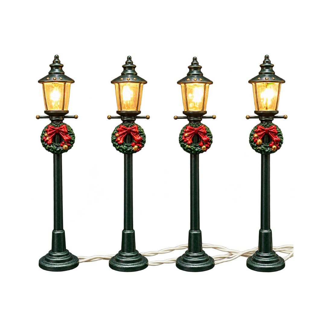 Set di 4 lampioni natalizi verdi con lanterna illuminata a luce calda, decorati con ghirlanda, fiocco rosso e piccole bacche dorate