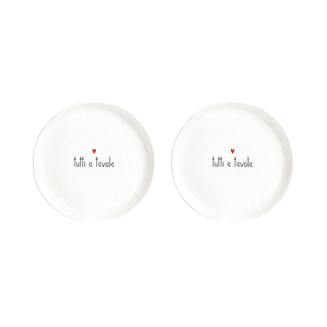 Set di due piatti da dessert con diametro di 21 cm in gres con scritta nera "tutti a tavola" e cuoricino rosso.