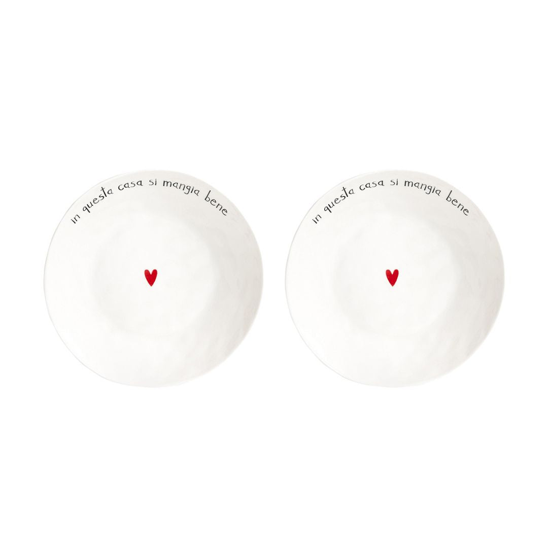 Set di due piatti fondi in grès con scritta nera "in questa casa si mangia bene" e cuoricino rosso al centro.