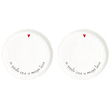 Set di due piatti piani in grès con scritta nera "in questa casa si mangia bene" e cuoricino rosso.