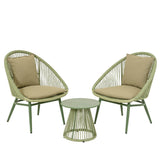 Set da esterno con due sedie intrecciate in fibra verde e cuscini con tavolino rotondo verde.