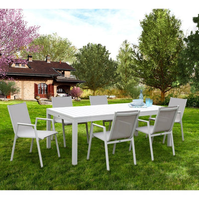 set pranzo pratic chiuso con attorno 6 sedie. Sullo sfondo un giardino