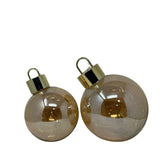 Coppia di sfere decorative color champagne con micro LED interni e finitura riflettente dorata, in due dimensioni diverse.