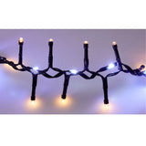 Dettaglio di catena luminosa 710 LED con cavo nero e luci alternate bianco caldo e bianco freddo, accese e intrecciate tra loro su sfondo neutro.