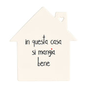 Sottopentola a forma di casetta in grès con scritta nera "in questa casa si mangia bene".